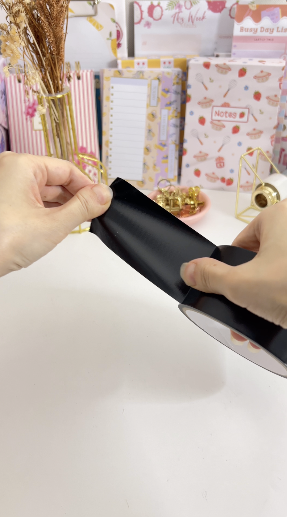 Pressing a strip of cloth tape over the planner spine