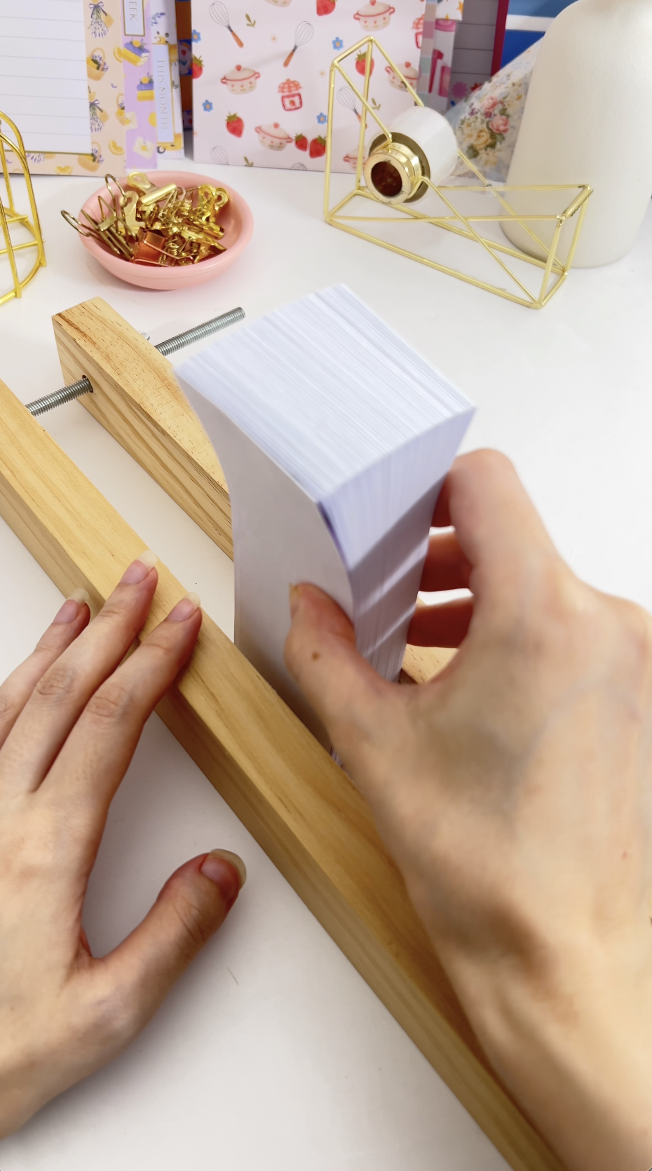 The folded stack clamped in a book press with the folded edges facing out
